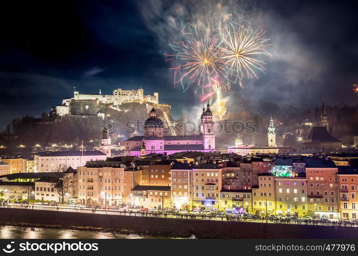 Colorful firework in the night: Old city of Salzburg and Festung Hohensalzburg at New Year's Eve. Magic