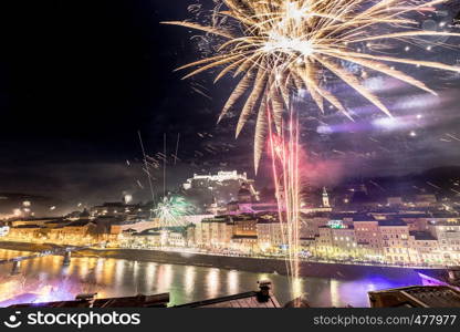 Colorful firework in the night: Old city of Salzburg and Festung Hohensalzburg at New Year's Eve. Magic