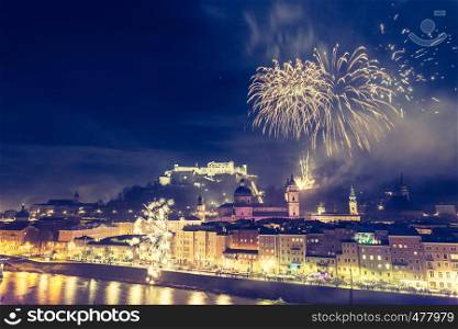 Colorful firework in the night: Old city of Salzburg and Festung Hohensalzburg at New Year's Eve. Magic