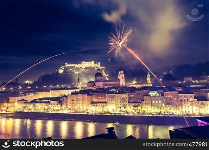 Colorful firework in the night: Old city of Salzburg and Festung Hohensalzburg at New Year's Eve. Magic