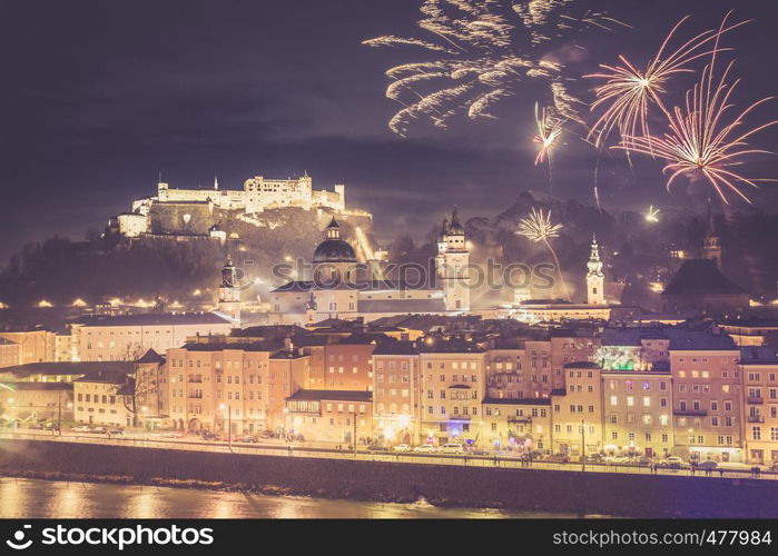 Colorful firework in the night: Old city of Salzburg and Festung Hohensalzburg at New Year's Eve. Magic