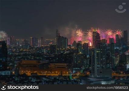 Colorful Firework with cityscape night light view of Bangkok skyline at twilight time. New Year celebration fireworks, Bangkok city,Thailand Fireworks light up to sky at Christmas & New Year festival with free space for text. No focus, specifically.