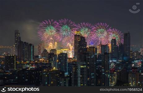 Colorful Firework with cityscape night light view of Bangkok skyline at twilight time. New Year celebration fireworks, Bangkok city,Thailand Fireworks light up to sky at Christmas & New Year festival with free space for text.