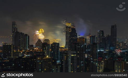 Colorful Firework with cityscape night light view of Bangkok skyline at twilight time. New Year celebration fireworks, Bangkok city,Thailand Fireworks light up to sky at Christmas   New Year festival with free space for text. No focus, specifically.