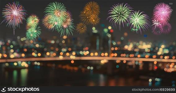 Colorful fireworks on skyline background with blurred city night illuminated lights bokeh