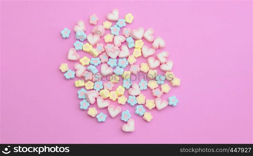 Colorful flatlay marshmallows on sweet pink background, pastel candy color sweet dessert with copy space