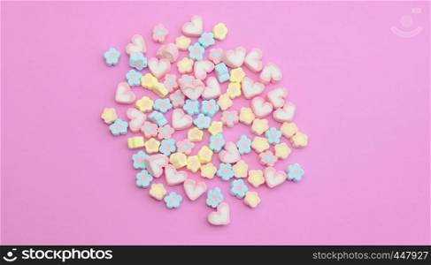 Colorful flatlay marshmallows on sweet pink background, pastel candy color sweet dessert with copy space