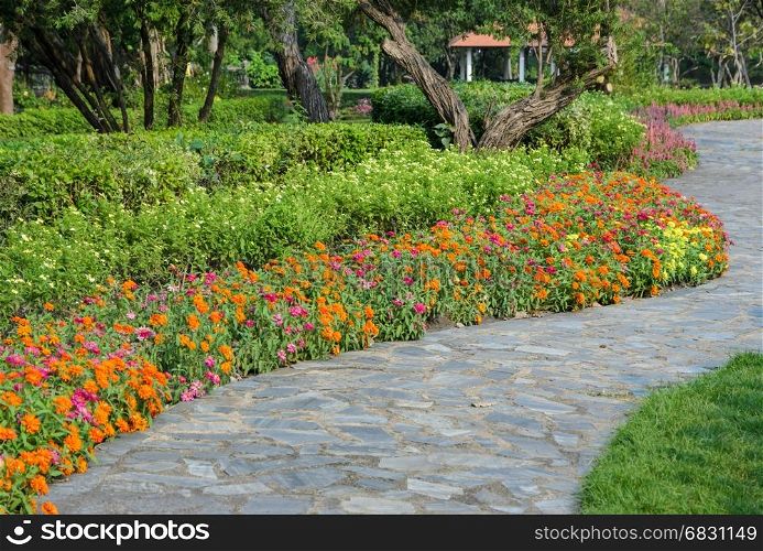 Colorful flower bed garden with stone pathway