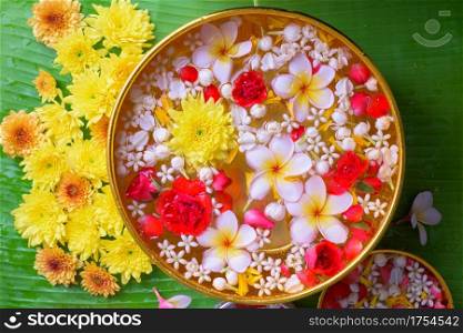 Colorful flower in water bowls decorating on Banana leaf for Songkran Festival or Thai New Year.