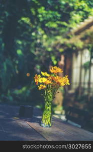 colorful flower on outdoor coffee table. Closeup of flower bouquet in a vase on a sunny summer day in cafe.. Closeup of flower bouquet in a vase on a sunny summer day in cafe.