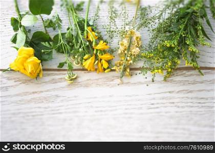 Colorful flowers in yellow and green on a wooden background in the springtime