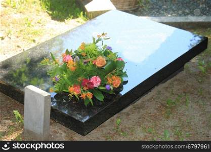 Colorful flowers on a black marble gravestone