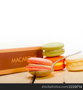 colorful french macaroons over a white rustic wood table 