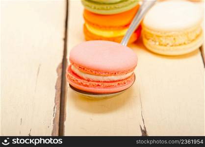 colorful french macaroons over a white rustic wood table