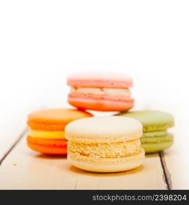 colorful french macaroons over a white rustic wood table 