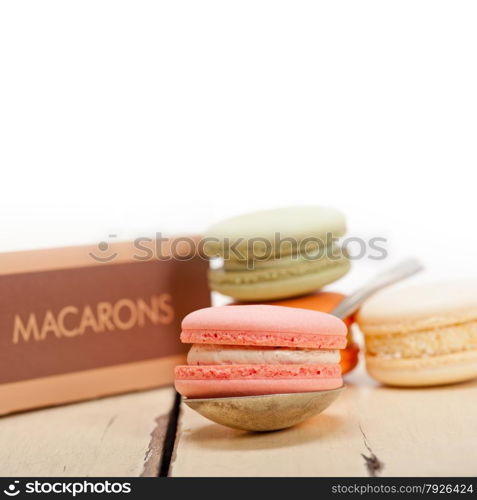 colorful french macaroons over a white rustic wood table