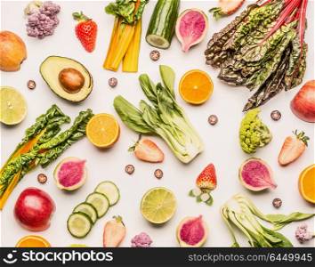 Colorful fruits and vegetables flat lay background with half of oranges,avocado, citrus,apples and berries , top view. Healthy food and clean eating ingredients concept