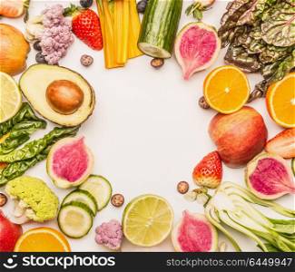 Colorful fruits and vegetables frame background with half of oranges, and berries , top view. Healthy food and clean eating ingredients concept
