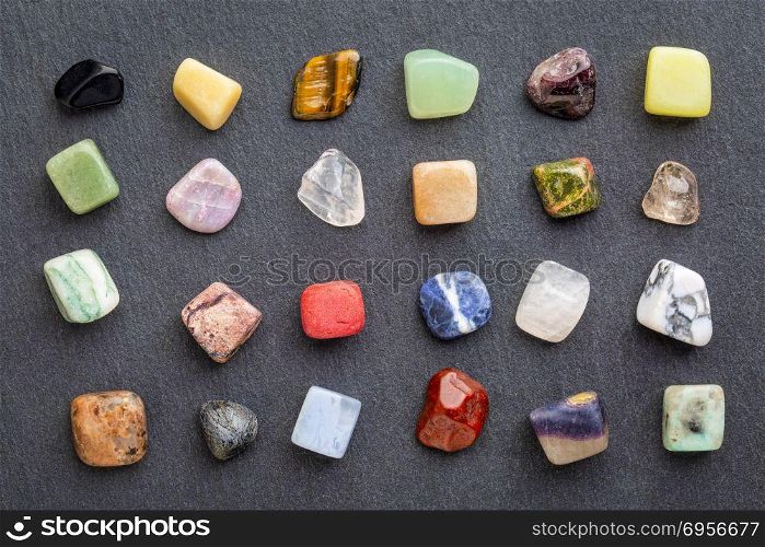 colorful gemstones on slate stone. set of polished, semiprecious, colorful gemstones against gray slate stone