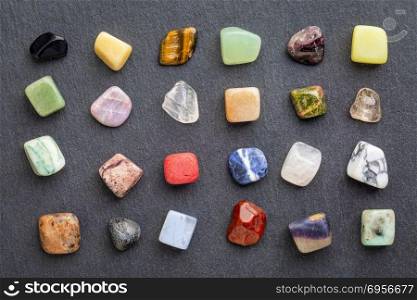 colorful gemstones on slate stone. set of polished, semiprecious, colorful gemstones against gray slate stone