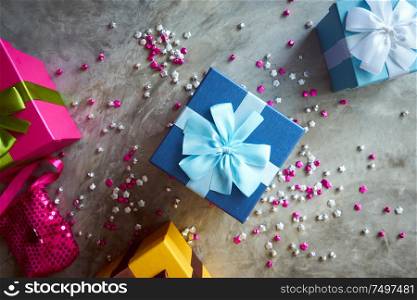 Colorful gift box with little star craft , cement texture desktop top view . Present gifts ,Christmas ,New year seasonal holiday give concept .