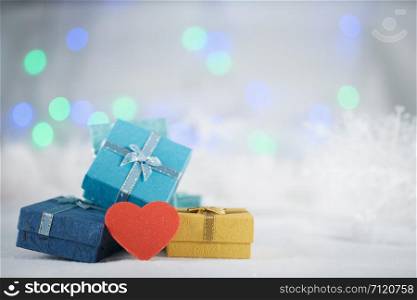 Colorful gift boxes and heart on the white fur on bokeh background, with copy space for season greeting. Merry Christmas or Happy New Year.AF point selection,blurred