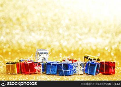 Colorful gift boxes on glitter golden background. Colorful holiday gifts