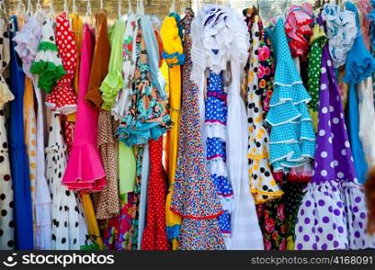 colorful gipsy flamenco dresses on rack hanged in Spain market