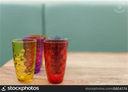 colorful glass on wood table in cafe restaurant, blur background