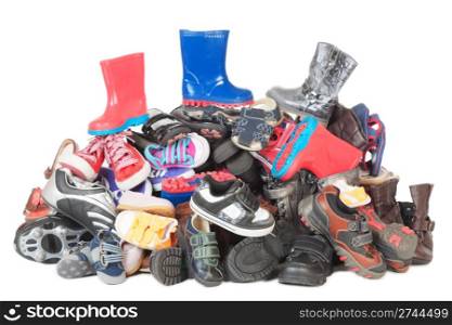 Colorful heap of old child boots and shoes isolated over white background