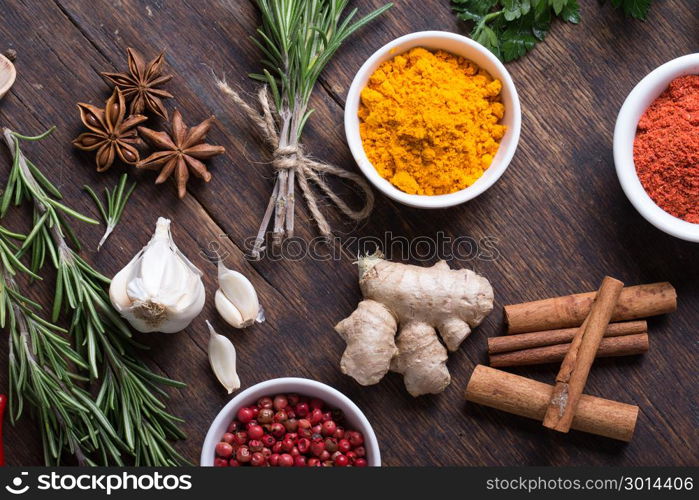 Colorful herbs and spices selection. Aromatic ingredients on wood table