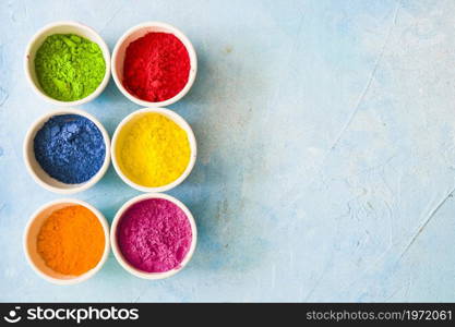 colorful holi color powder inside white bowls painted blue backdrop. High resolution photo. colorful holi color powder inside white bowls painted blue backdrop. High quality photo