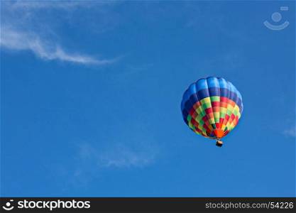Colorful hot-air balloon in flight against a blue sky. Colorful hot-air balloon in flight