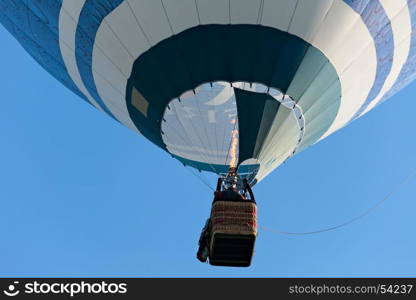Colorful hot-air balloon is inflated for flight against a blue sky. Colorful hot-air balloon is inflated for flight