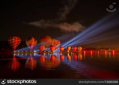 Colorful hot air balloons flying over river on night festival
