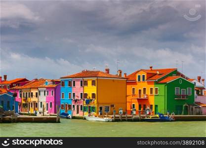 Colorful houses and boats on the famous island Burano, view from the sea, Venice, Italy