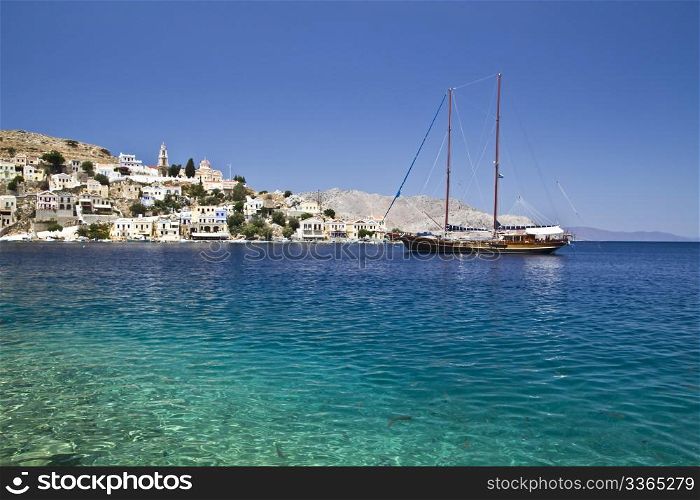 Colorful houses and sailing boat in Symi island of Greece