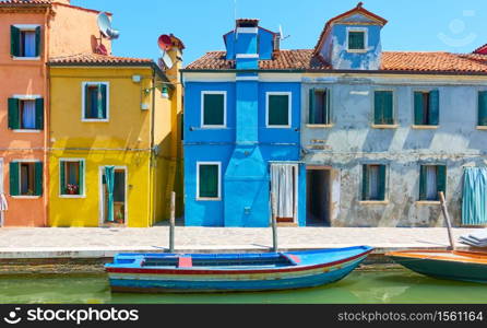 Colorful houses by canal in Burano island in Venice, Italy - Italian cityscape