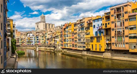 Colorful houses, Eiffel bridge and Saint Mary Cathedral at background in Girona, in a beautiful summer day, Catalonia, Spain