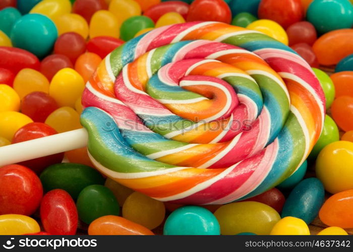 Colorful jelly beans and lollipop close to wallpaper