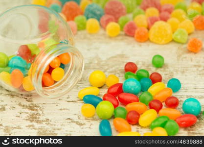 Colorful jelly beans of different sizes close to wallpaper