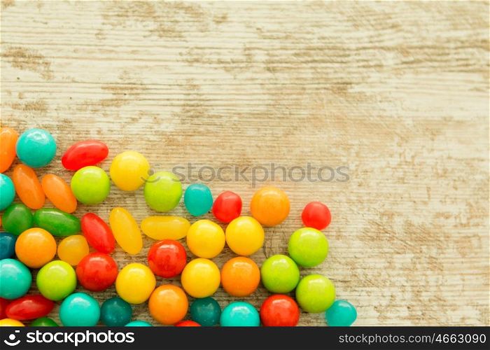 Colorful jelly beans of different sizes close to wallpaper