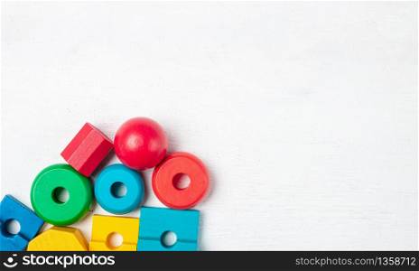 Colorful kids toys on white wooden background. Top view. Flat lay. Copy space for text