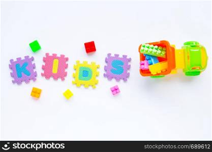 "Colorful Kids toys with alphabet "KIDS" Puzzle Pieces on white background."