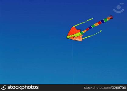 Colorful kite fluttering and flying in blue sky