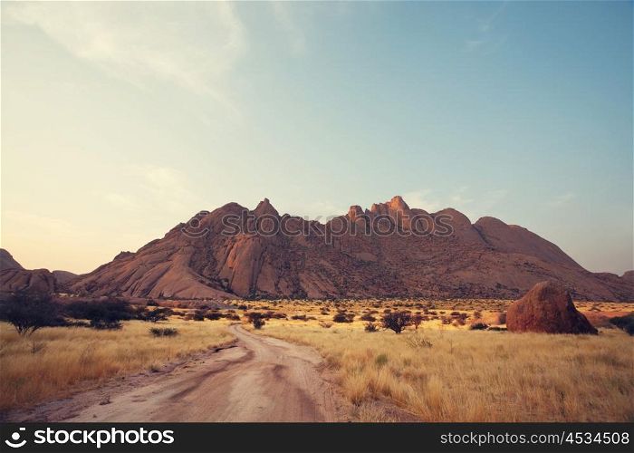 Colorful landscapes of the orange rocks in the Spitscoppe mountains in Namibia on a sunny hot day.