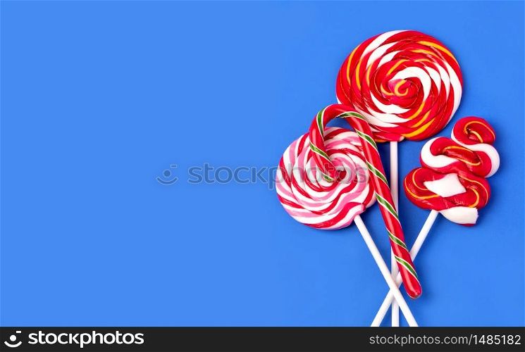Colorful lollipop on blue background. Flat lay. Minimal concept