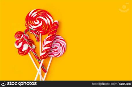 Colorful lollipop on yellow background. Flat lay. Minimal concept