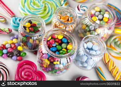 Colorful lollipops and different colored round candy and gum bal. Lollipops and sweet candies of various colors