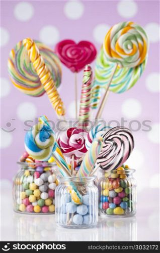 Colorful lollipops and different colored round candy and gum bal. Lollipops and sweet candies of various colors